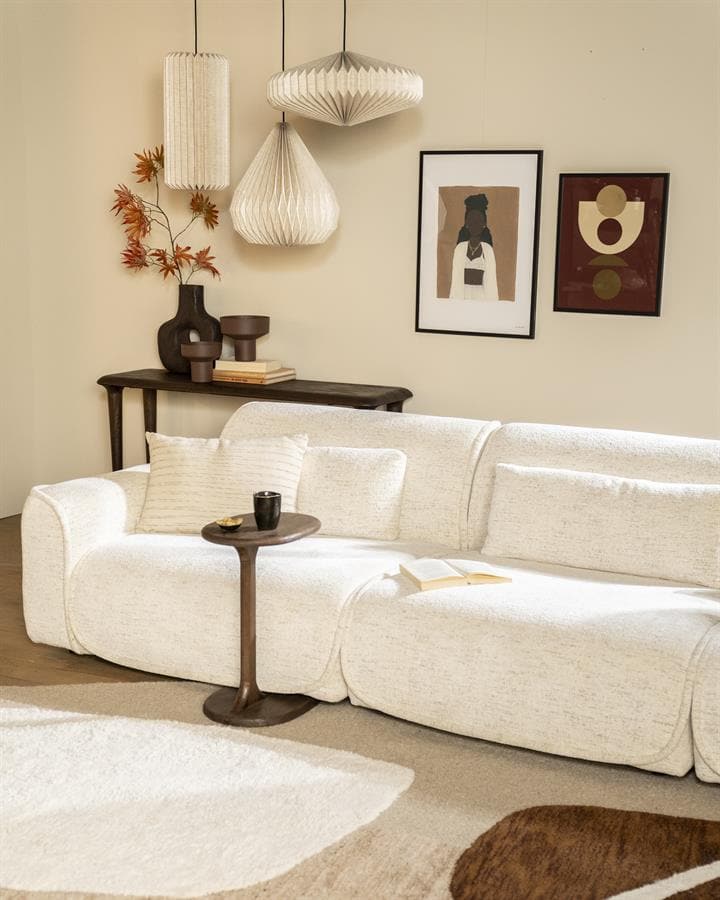 Luxe witte stoffen hoekbank in een sfeervolle woonkamer met stijlvolle zwarte salontafel, kunst aan de muur en trendy hanglampen, perfect voor een moderne en gezellige woonruimte.