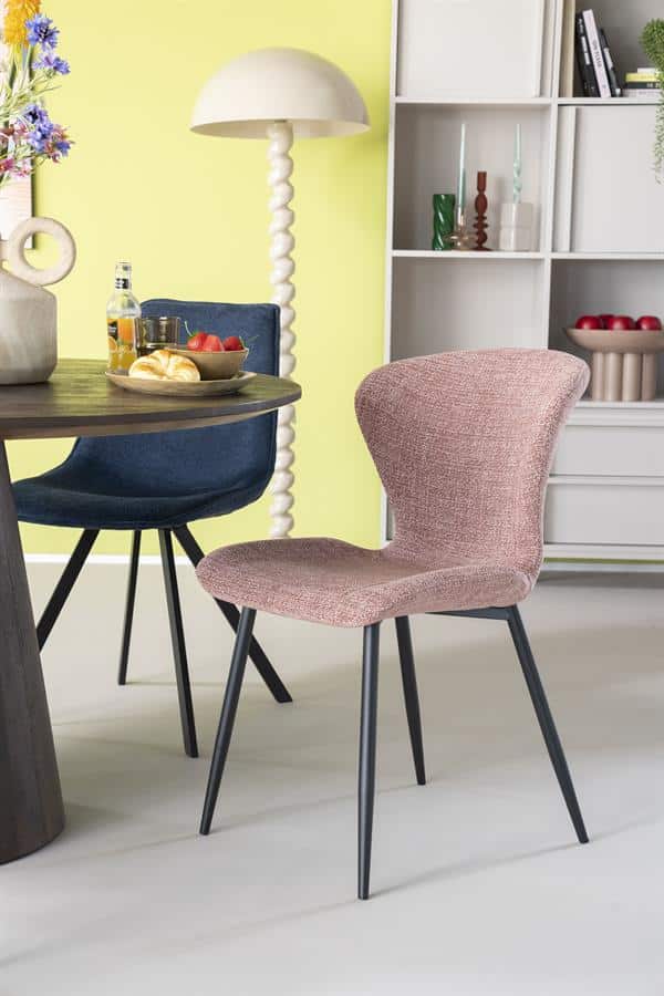 Comfortabele eetkamerstoel met zachte bekleding en slanke zwarte poten in een modern interieur.