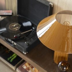 Vintage platenspeler met een draaiende vinylplaat op een houten meubel.