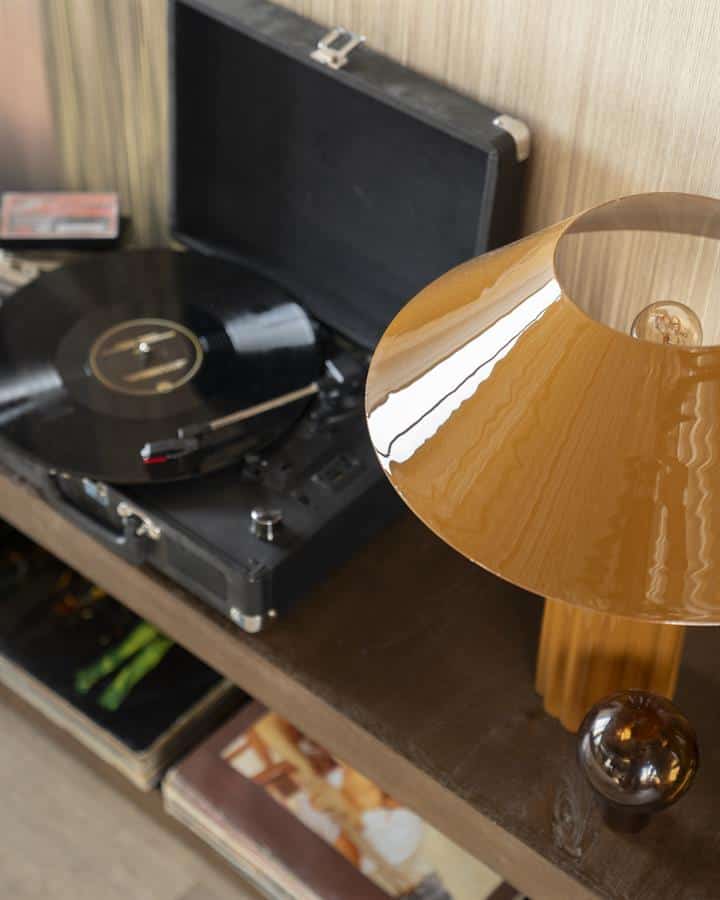 Vintage platenspeler met een draaiende vinylplaat op een houten meubel.