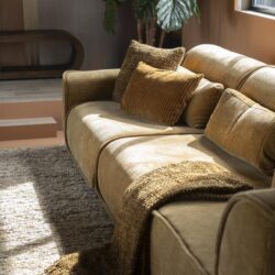 Zeer stijlvolle beige bank met kussens en plaid, ideale woonkamer meubel voor een gezellige en comfortabele sfeer, gemaakt door Mokana Meubelen.
