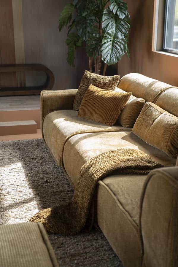 Zeer stijlvolle beige bank met kussens en plaid, ideale woonkamer meubel voor een gezellige en comfortabele sfeer, gemaakt door Mokana Meubelen.