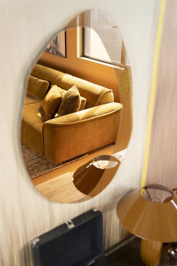 Elegant houten wandspiegel met gouden sofa en accessoires, perfect voor een gezellige woonkamer inrichting. Mokana Meubelen biedt stijlvolle en op maat gemaakte meubeloplossingen.