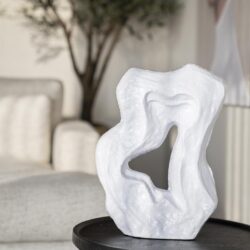 Moderne witte sculptuur van keramiek op zwart bijzettafel voor stijlvolle woondecoratie.