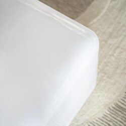 Strak wit meubel met afgeronde hoeken en glanzende afwerking in modern wooninterieur.