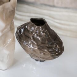 Unieke keramische vaas met een ruwe, handgemaakte textuur in glanzend bruin, perfect voor moderne interieurdecoratie en bloemen.