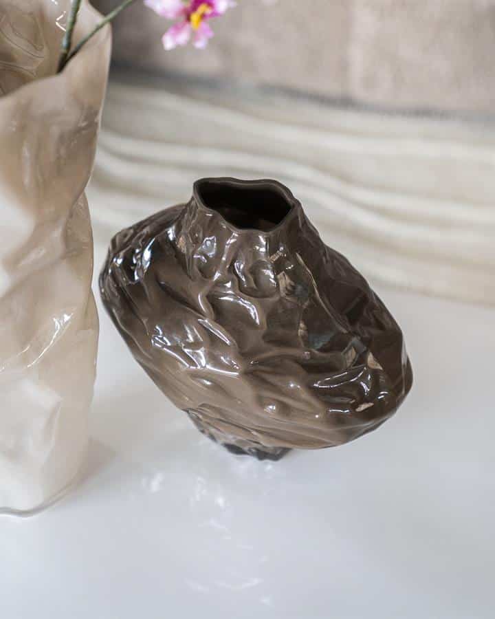 Unieke keramische vaas met een ruwe, handgemaakte textuur in glanzend bruin, perfect voor moderne interieurdecoratie en bloemen.