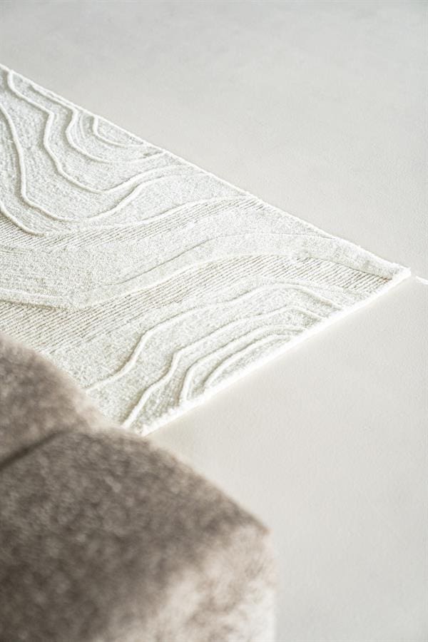Luxueuze witte en beige tapijt met abstracte golvende patronen, perfect voor moderne woonkamerinterieurs en comfortabele sfeercreatie bij Mokana Meubelen.