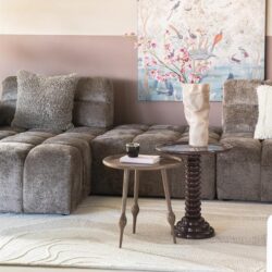 Kleine ronde bijzettafel en hoge salontafel met bloemenvaas in een modern woonkamer, perfect voor stijlvolle interior decoraties en meubels.