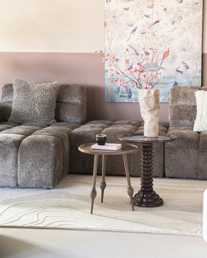 Kleine ronde bijzettafel en hoge salontafel met bloemenvaas in een modern woonkamer, perfect voor stijlvolle interior decoraties en meubels.