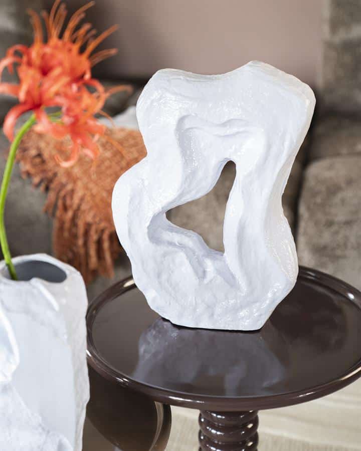 Unieke witte kunstzinnige sculptuur op ronde tafel, perfect voor modern interieurdecoratie en luxe woninginrichting. Daarnaast zien we stijlvolle vazen met bloemen, ideaal voor een eigentijdse woonkamer.