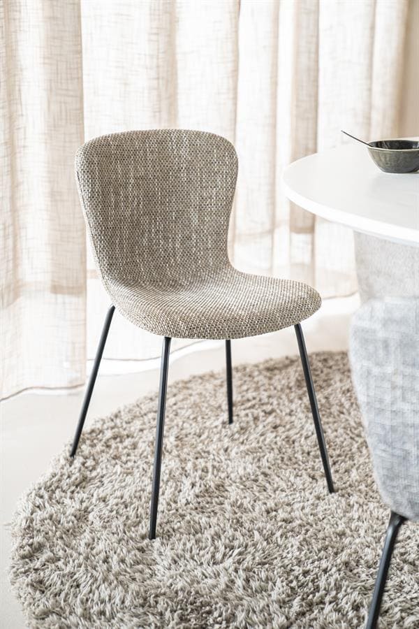 Elegante eetkamerstoel met stoffen bekleding en zwarte metalen poten, perfect voor modern interieur, comfortabel en stijlvol, onderdeel van Mokana Meubelen collectie.