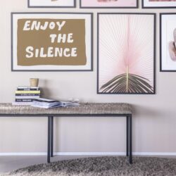 Minimalistische tafel met boekenkast en decoratieve kunst aan de muur, moderne woonkamer inrichting, design meubels and jonger interieur.