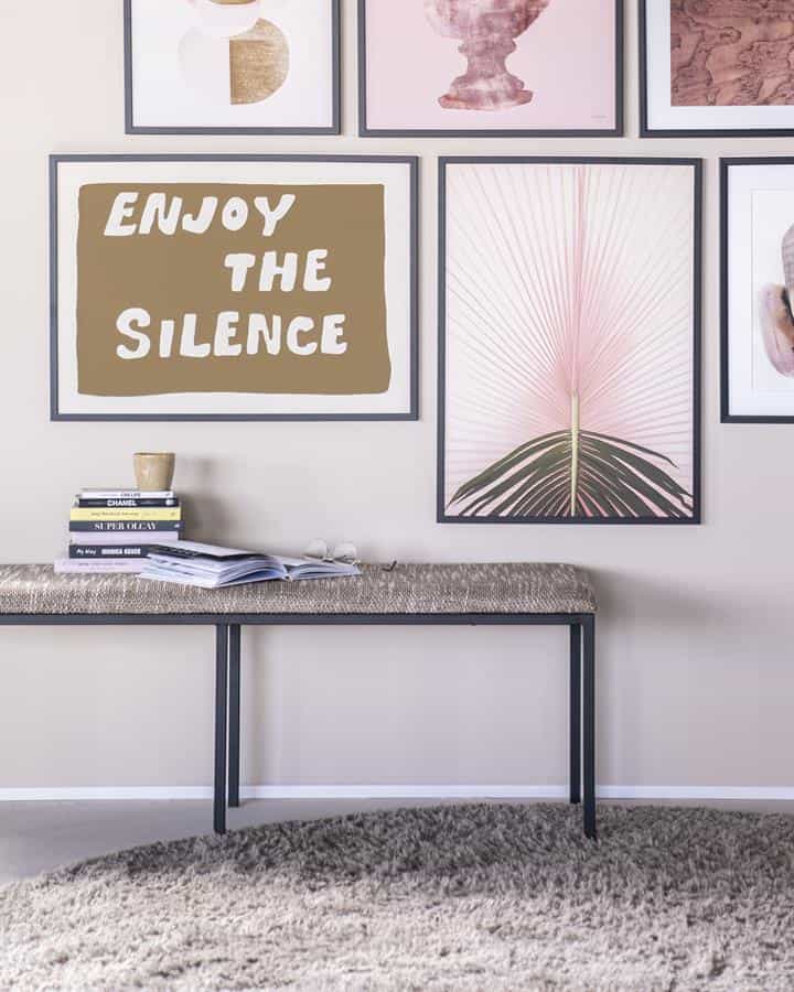 Minimalistische tafel met boekenkast en decoratieve kunst aan de muur, moderne woonkamer inrichting, design meubels and jonger interieur.