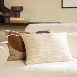 Ruime stijlvolle woonkamer met beige bank en decoratieve kussens, perfect voor een modern interieur.