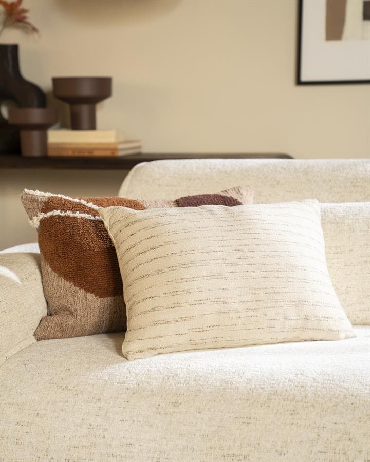 Ruime stijlvolle woonkamer met beige bank en decoratieve kussens, perfect voor een modern interieur.