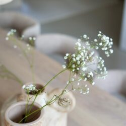 Vaas met witte bloemen op een houten tafel, Scandinavisch interieur, modern en minimalistisch, stijlvolle woondecoratie.