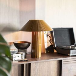 Minimalistisch houten dressoir met vintage lamp en platenspeler, stijlvolle woondecoratie, warme sfeer, modern design, Mokana meubelen in een eigentijdse interieursetting.