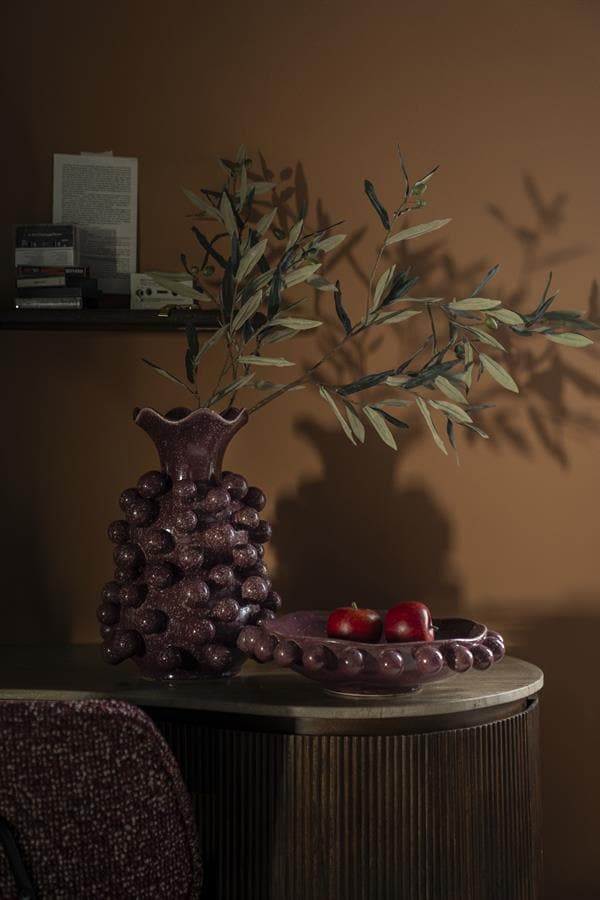 Botervaas met olijftakken en appels op bijzettafel voor een elegant interieur, vintage decor en stijlvolle woninginrichting.