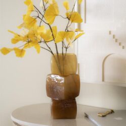 Vaas met gele bladeren op een witte tafel, modern interieur decor, natuurlijke esthetiek, stijlvolle woonaccessoires, elegante inrichting, hoge kwaliteit meubeldesign.