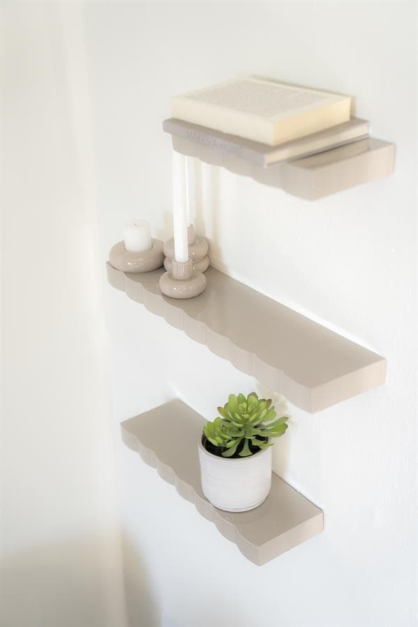 Elegante wandplank met decoratieve accessoires en een plant voor een moderne interieurstijl.