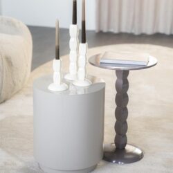 Strakke witte salontafel met decoratieve kandelaars en bijzettafel in modern design, perfect voor een stijlvolle woonkamer inrichting.