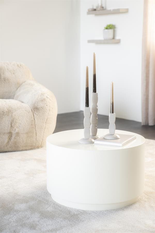 Kaarsenstandaard met drie kaarsen op wit bijzettafel in modern woonkamer.