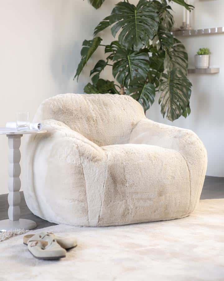 Comfortabele zachte bank met organisch design en wolachtige bekleding, perfect voor een modern interieur.