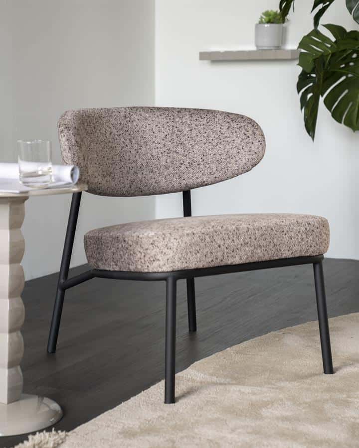 Comfortabele vintage houten stoel met zachte bekleding en strakke zwarte metalen poten, perfect voor modern interieur en woonkamer.