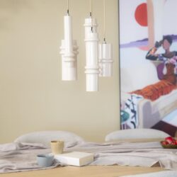 Moderne witte hanglampen boven een eettafel met comfortabele stoelen en stijlvolle decoratie, perfect voor een eigentijdse huisinrichting.