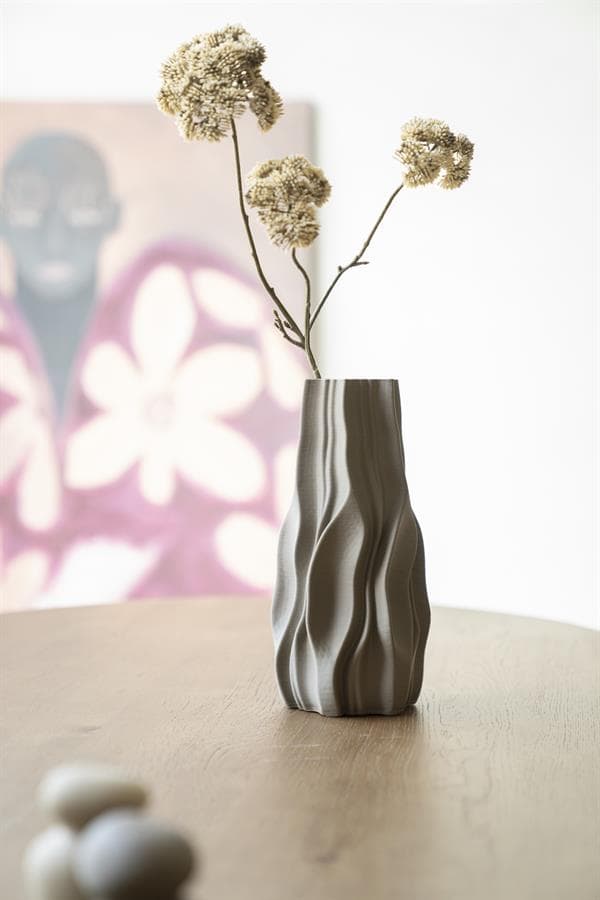 Kleine vaas met gedroogde bloemen op een houten tafel in een modern interieur, stijlvolle decoratie voor woonkamer of eetruimte.