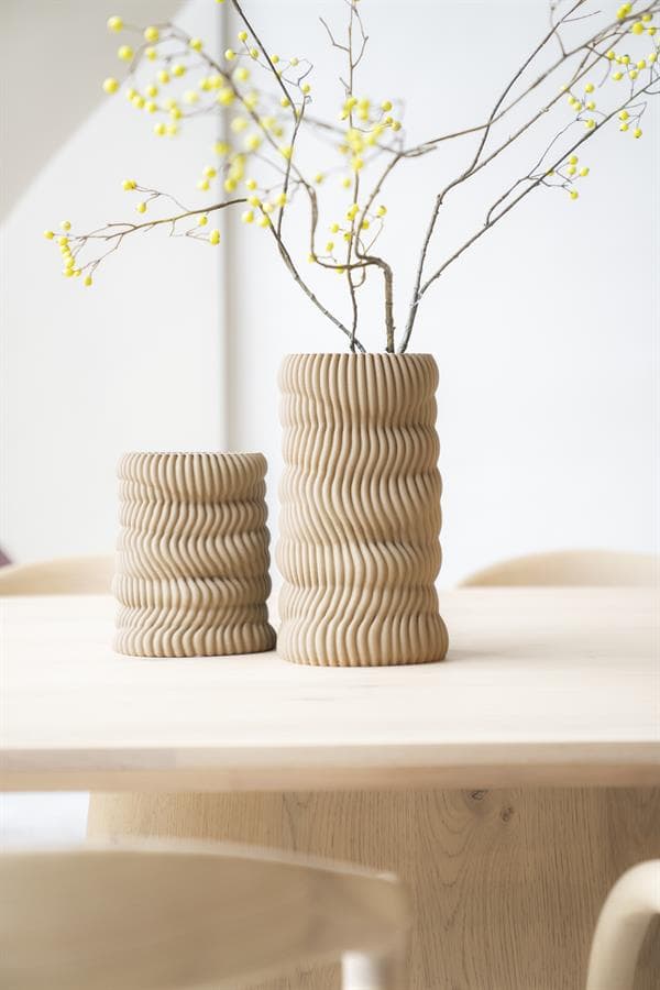Zachte beige keramische vazen met golvend reliëf op eettafel, decoratief bloemstuk, modern interieur, elegante woonaccessoires, natuurlijke materialen, design vaas, Mokana meubelen, interieurstyling.