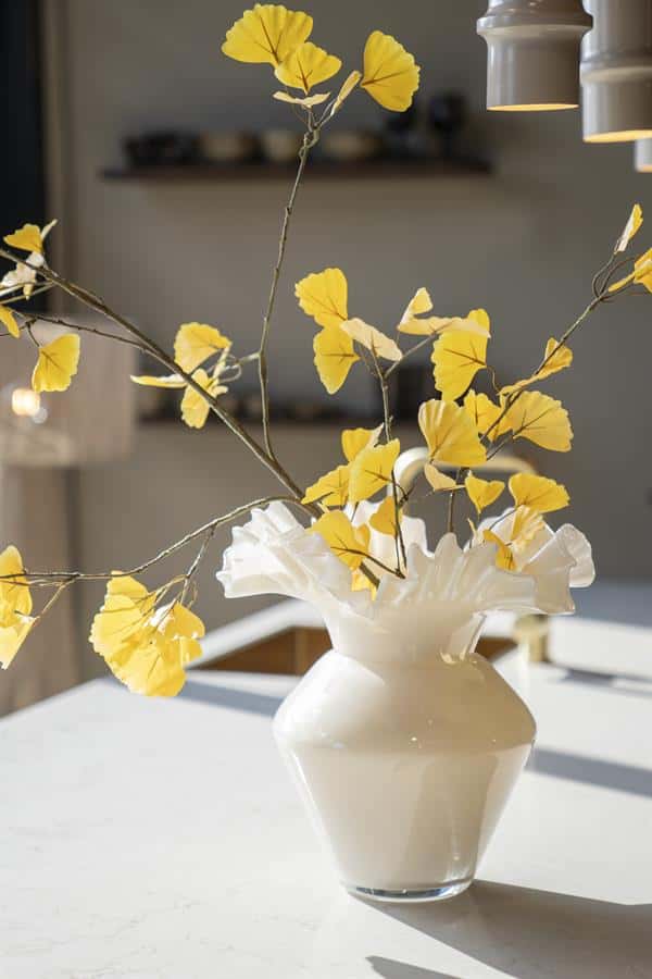 Grote witte vaas met gele bladeren en takken, elegante woondecoratie, minimalistisch interieuraccessoire, natuurlijke stijl, Mokana Meubelen.
