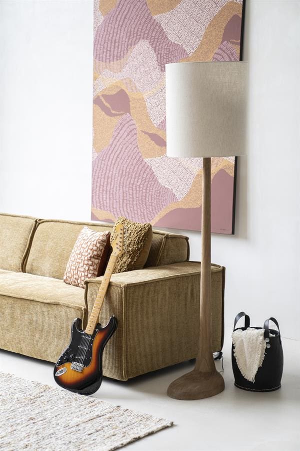 Decoratieve woonkamer met vintage bank, moderne lamp, sprekende muurkunst en elektrische gitaar voor een stijlvolle en praktische interieurstijl.