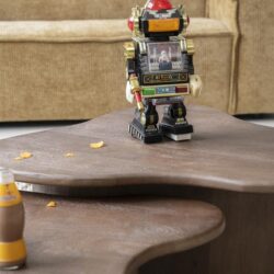 Robothuisje op een houten salontafel in woonkamer, speelse sfeer met snackresten, ideaal voor kindvriendelijke inrichting.