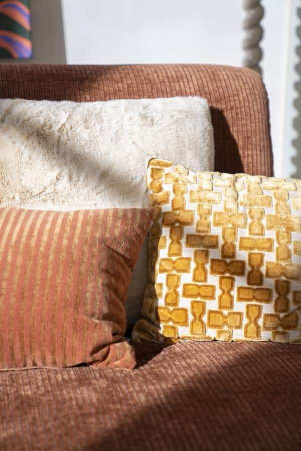 Elegante kussens op een gezellige bank met een warme, rustgevende uitstraling, perfect voor een comfortabele woonkamer.