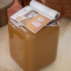 Elegante bruine bijzettafel van Mokana meubelen met leesmateriaal erop, modern en functioneel design, perfect voor stijlvolle woonkamers.