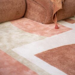 Zachte velvet bank met antracietkleurige accessoires en bijpassend tapijt voor een warme en stijlvolle woonkamer.