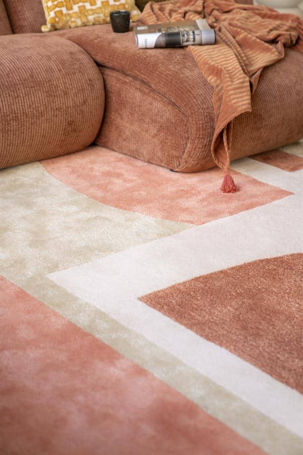 Zachte velvet bank met antracietkleurige accessoires en bijpassend tapijt voor een warme en stijlvolle woonkamer.