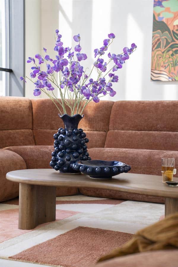 Vaas met kunstbloemen op salontafel in gezellige woonkamer, modern interieur met Mokana meubels.
