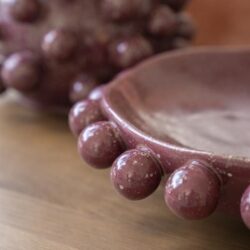 Kaasplankje met decoratieve bolletjes rand, vervaardigd uit keramiek in een warme, aardse tint, perfect voor servies en tafelsetting.