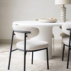 Elegante eetkamerstoel met beige bekleding en zwarte metalen frame, perfect voor modern interieurdesign en eetkamertafels van Mokana Meubelen.