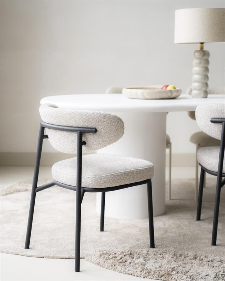 Elegante eetkamerstoel met beige bekleding en zwarte metalen frame, perfect voor modern interieurdesign en eetkamertafels van Mokana Meubelen.