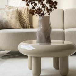 Vaas met gedroogde planten op een modern bijzettafeltje in een stijlvolle woonkamer.