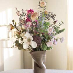 Bloemenvaas met fleurige bloemen, stijlvolle bloemarrangement in modern keramieken vaas, decoratief bloemstuk voor interieur, Mokana Meubelen.