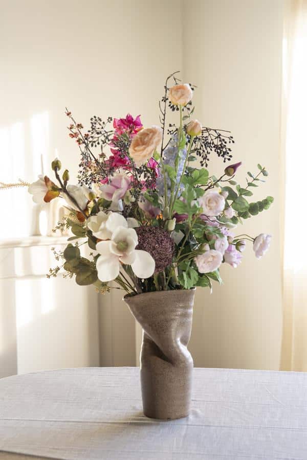 Bloemenvaas met fleurige bloemen, stijlvolle bloemarrangement in modern keramieken vaas, decoratief bloemstuk voor interieur, Mokana Meubelen.