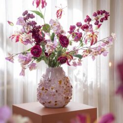 Groteruiker vaasje met kleurrijke bloemen, rozes en orchideeën, decoratief interieurstuk in zachte pastelkleuren voor een stijlvolle woonkamer of entree.