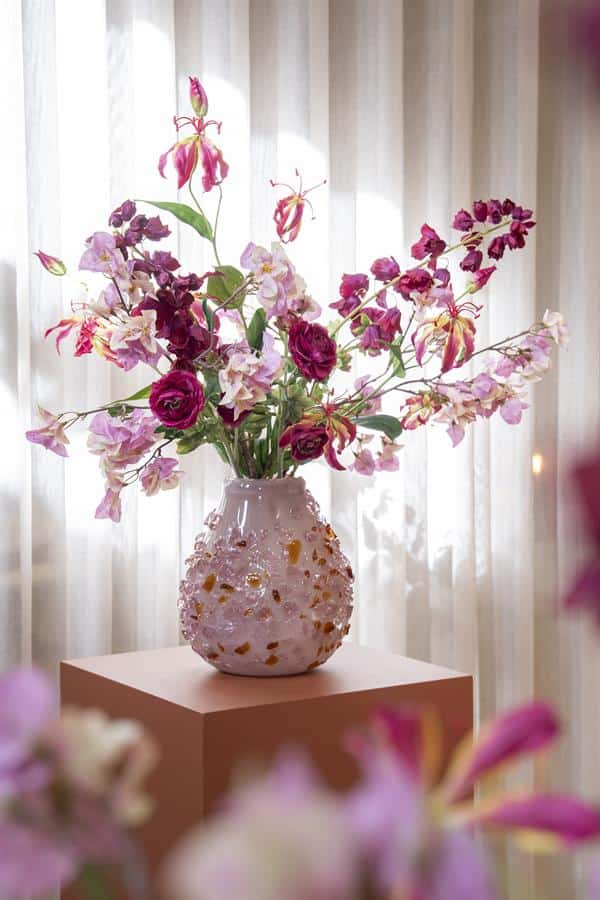 Groteruiker vaasje met kleurrijke bloemen, rozes en orchideeën, decoratief interieurstuk in zachte pastelkleuren voor een stijlvolle woonkamer of entree.