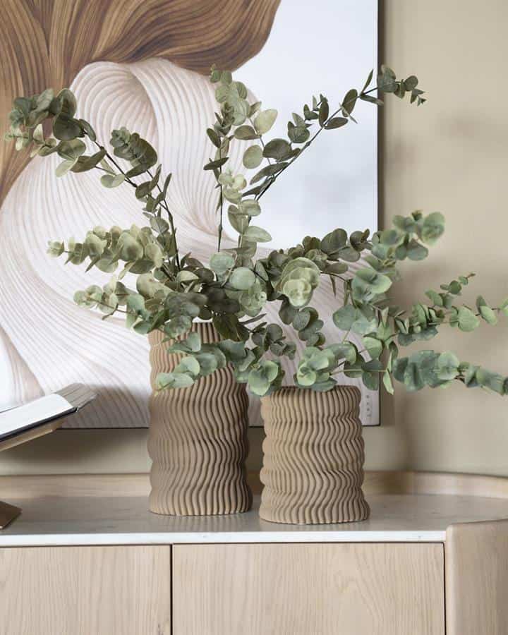 Elegante eikenhouten vazen met ribbelstructuur en eucalyptus takken, perfect voor een moderne interieurdecoratie. Tijdloos en stijlvol, ideaal voor in de woonkamer of entrée.