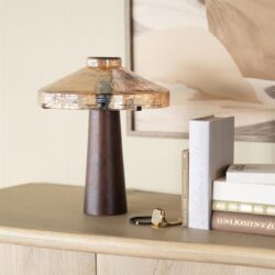 Vintage houten tafelklok met bruin houten voet en koperkleurige styling, decoratief op een witte kast.